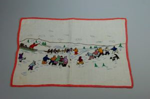 Image: Embroidered place mat with Inuit figures and dog team